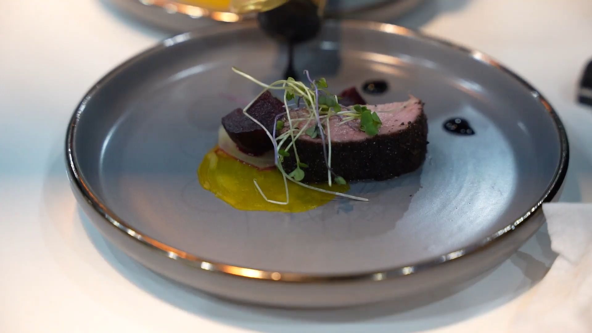 A course being plated in the kitchen